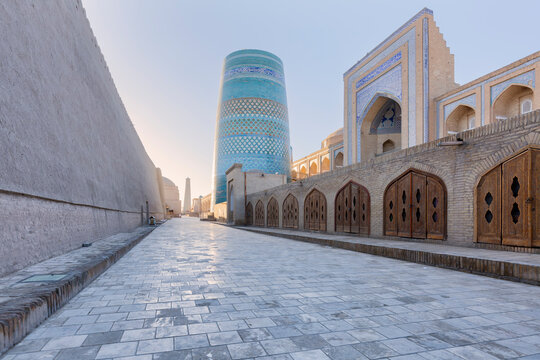 Iconic Kalta Minor minaret and ancient madrasah at sunrise in the old city of Ichan-Kala. Traslate text:  In the name of Allah Almighty who create