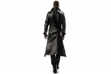 Fototapeta premium A person wearing a black trench coat walks down the street