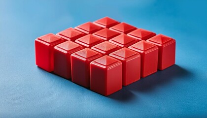Obraz premium red plastic geometric cubes contrasted on blue background. Construction toys on geometric shapes. Arranged in rows.