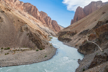 A majestic river flows through a canyon nestled between two towering mountains, Trek to Puktal Monastery, Zanskar