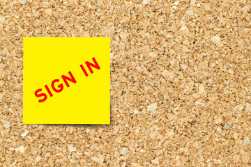 Yellow note paper with word sign in on cork board background with copy space