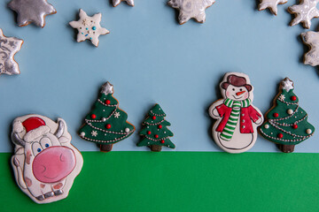 Colorful Christmas cookies shaped like trees, snowmen, and stars on a blue and green background. Perfect for holiday-themed projects.