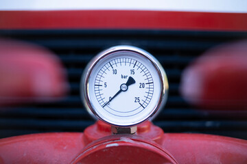 Pressure gauge for measuring water pressure in Bar on a fire truck pump.