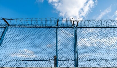 Fototapeta premium High security fence with barbed wire on border