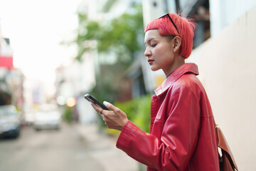 Asian woman using mobile phone to call online taxi.