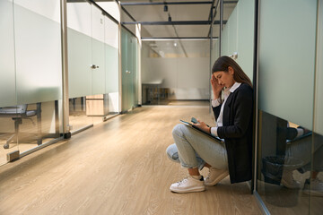 Girl in a jacket sits and looks at the phone