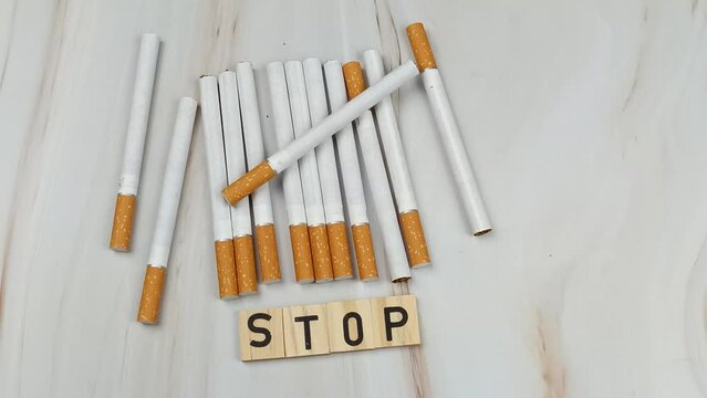 tas de cigarettes, vue du dessus, avec le mot Stop &eacute;crit en lettres en bois dessus.