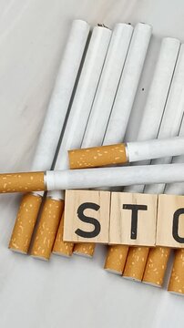 tas de cigarettes, vue du dessus, avec le mot Stop &eacute;crit en lettres en bois dessus.