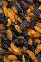 Mix of big black and golden raisins. Top view.