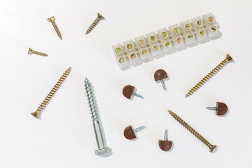 Various screws, cable connection strip and shelf supports on white background.