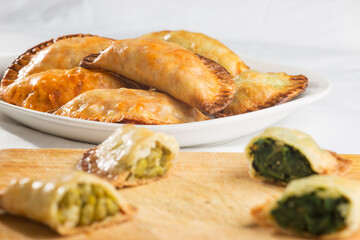 Assortment of homemade lactose-free dumplings, pea and spinach, on a wooden board.