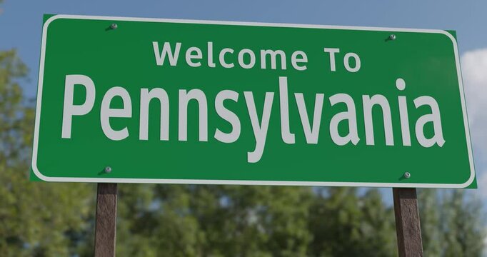 Driving By A Welcome To Pennsylvania Green Road Sign Against a Blue Sky and Clouds.
