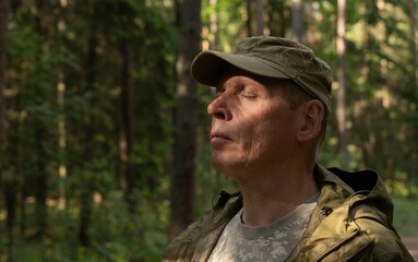 Obraz premium . Man enjoying nature, walking in woods, breathing, inhaling fresh air in summer forest, closing eyes.