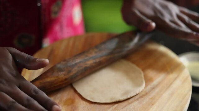 The process of preparing dough for a popular Asian flatbread using a wooden rolling pin