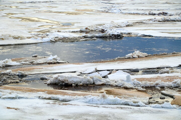 Spring flood, river with remnants of ice, melting ice, landscape river ice spring, thawed dangerous ice.