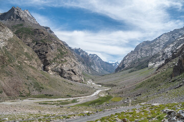 A dirt road through a field with mountains in the background, Zanskar, Himalayas