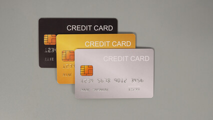 Three credit cards on grey background.
