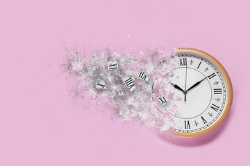 Clock shattering into pieces on pink background. Flow of time