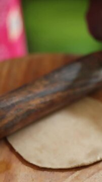 The process of preparing dough for a popular Asian flatbread, such as Roti, Naan, Paratha, Chapati, Puri, Bhatura, Kulcha, Dosa, Appam, Idiyappam, Malabar Parotta, involves using a wooden rolling pin.