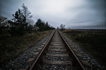 Fototapeta premium Railroad tracks. Straight railway line in twilight.