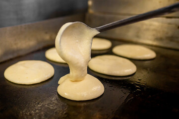 Close-up of pancake batter being poured onto a hot surface