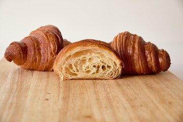 Inside crumb of a cut croissant on a wooden board and white background with space for text