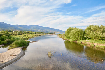 Lozoya River flowing into the Pinilla reservoir among vegetation in spring, in the Guadarrama National Park, in Madrid, Spain