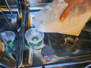 A woman who gradually pours sea salt into the dishwasher.