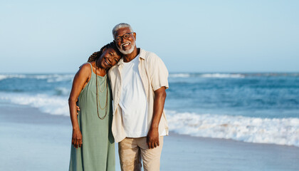Joyful mature African American couple strolling on the beach