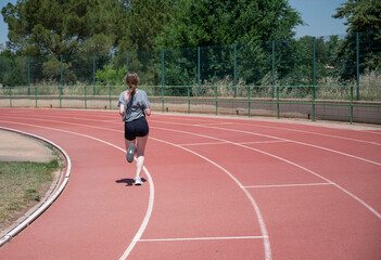 Young female athlete running on a track