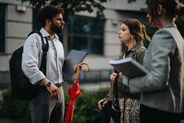 Young startup professionals using technology and brainstorming new project strategies while having an outdoor business meeting