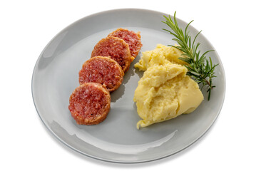 Cotechino slices typical Italian cooked salami with mashed potatoes and rosemary branch in plate isolated