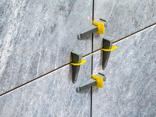 tile leveling system, laying gray marble effect porcelain tiles on the wall