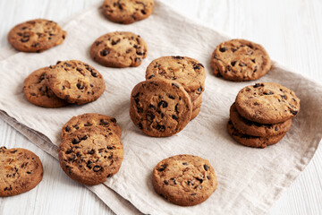 Homemade Gooey Chocolate Chip Cookies on a white wooden background, side view.