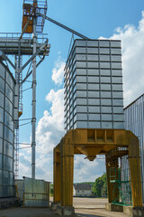 silver silos on agro manufacturing plant for processing drying cleaning and storage of agricultural products, flour, cereals and grain. Large iron barrels of grain. Granary elevator
