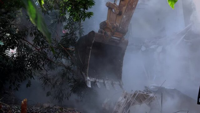Bulldozer is digging, smoke pollutes landscape, harming wildlife and trees