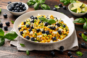 Blueberry Corn Feta Salad in white plate on wooden table. Healthy food