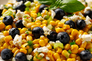 Blueberry Corn Feta Salad in white plate on wooden table. Healthy food