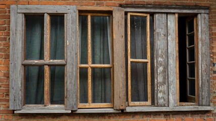 Window with broken glass in old building Wooden window frame with partially broken glass in old abandoned brick building
