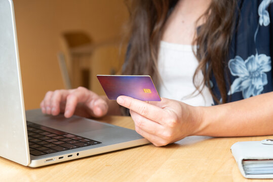 Woman with credit card shopping online using laptop