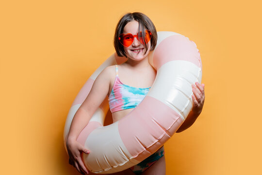 Young girl with swim ring in a summer-themed studio shoot