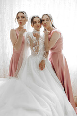 Three women posing for a picture, one of them is wearing a wedding dress. Scene is lighthearted and fun, as the women are making silly faces and posing for the camera