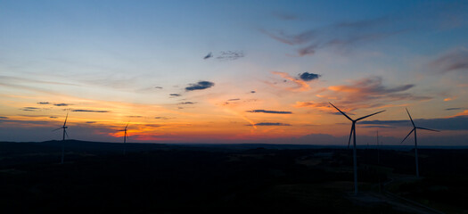 wind turbine in the countryside in the time of sunset background. Wind Turbines at Sunset. Aerial view of a wind farm at sunset.