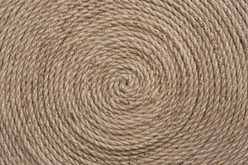 Natural fiber rope arranged in a circular pattern. The detailed texture and earthy beige tones create a rustic and organic aesthetic, perfect for backgrounds, crafts, and eco-friendly projects.
