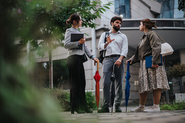 Young business people using technology and discussing a new project while brainstorming ideas and strategizing for success outdoors.