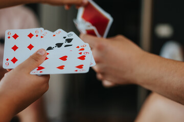 Close-up of a family enjoying a fun card game at home, bonding and spending quality time together.