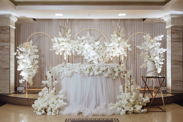 A beautifully decorated table with white flowers and a cake. The table is set for a special occasion, and the flowers and cake add a touch of elegance and festivity to the scene