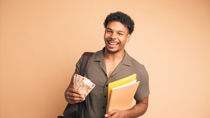 Happy young male student displaying scholarship money in beige studio