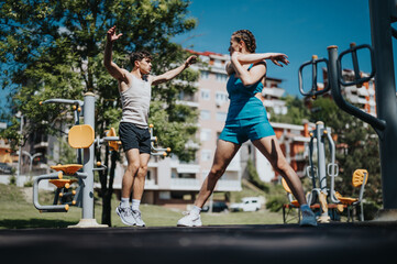 Young man and woman engaged in outdoor fitness workout in a park, focusing on health, exercise, and wellness on a sunny day.