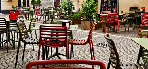 chairs and tables of an outdoor bar during the aperitif time in a restaurant on the Ligurian Riviera in summer 2024